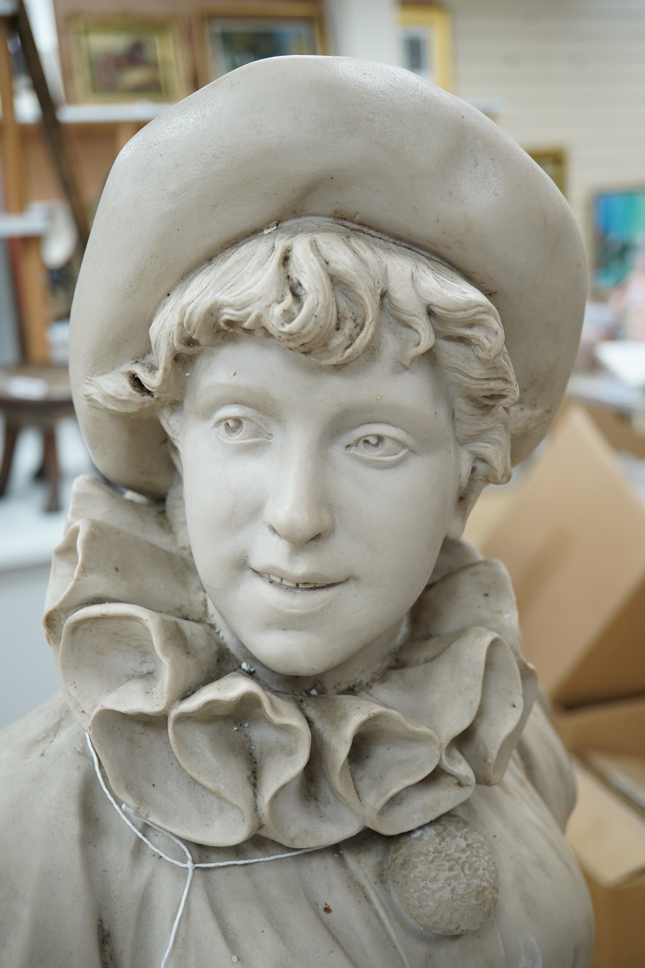 A composition bust of a boy on stand in a hat, ruff and pom-pom buttoned top, inscribed ‘A Azza’, 55cm high. Condition - fair